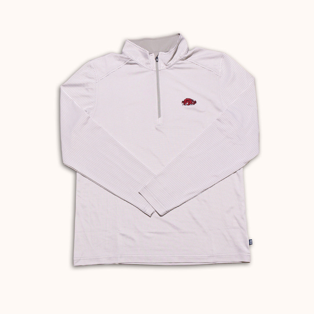 A light pink and white striped long-sleeve quarter-zip pullover with a small red Arkansas Razorbacks logo on the left chest, displayed flat against a cream background.