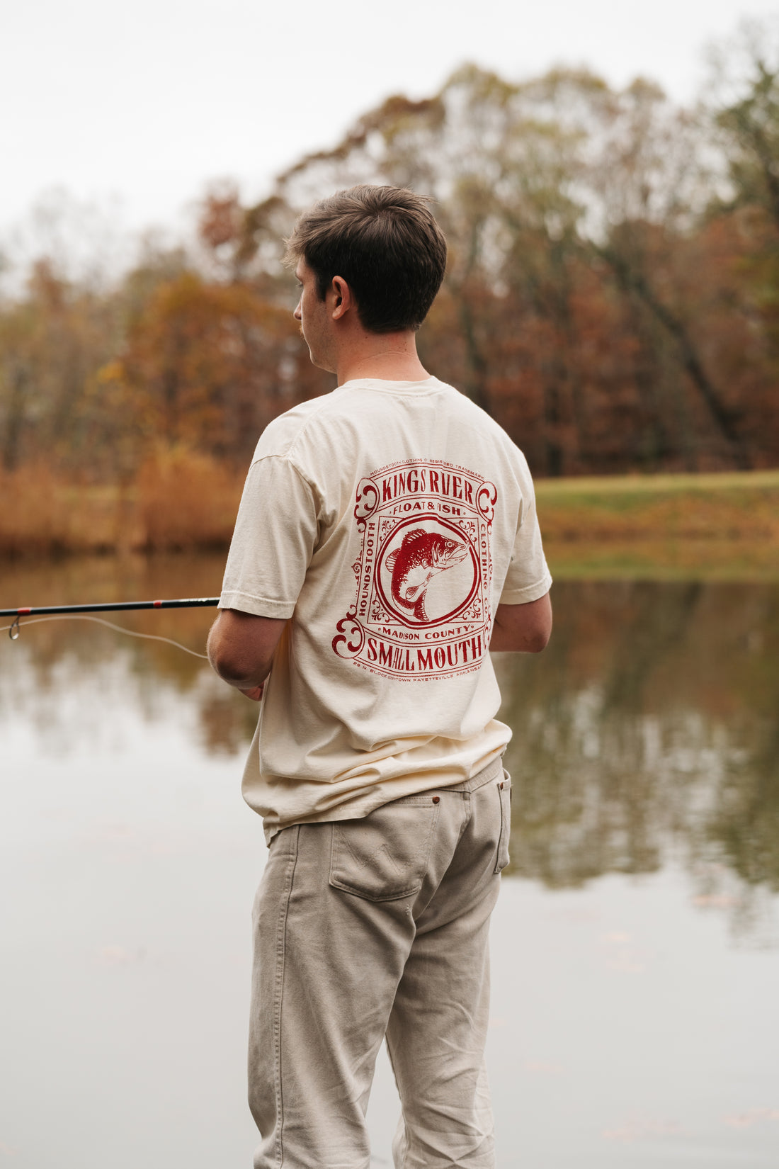 Cream colored t shirt with a red drawing of a small mouth bass flailing on Kings River.